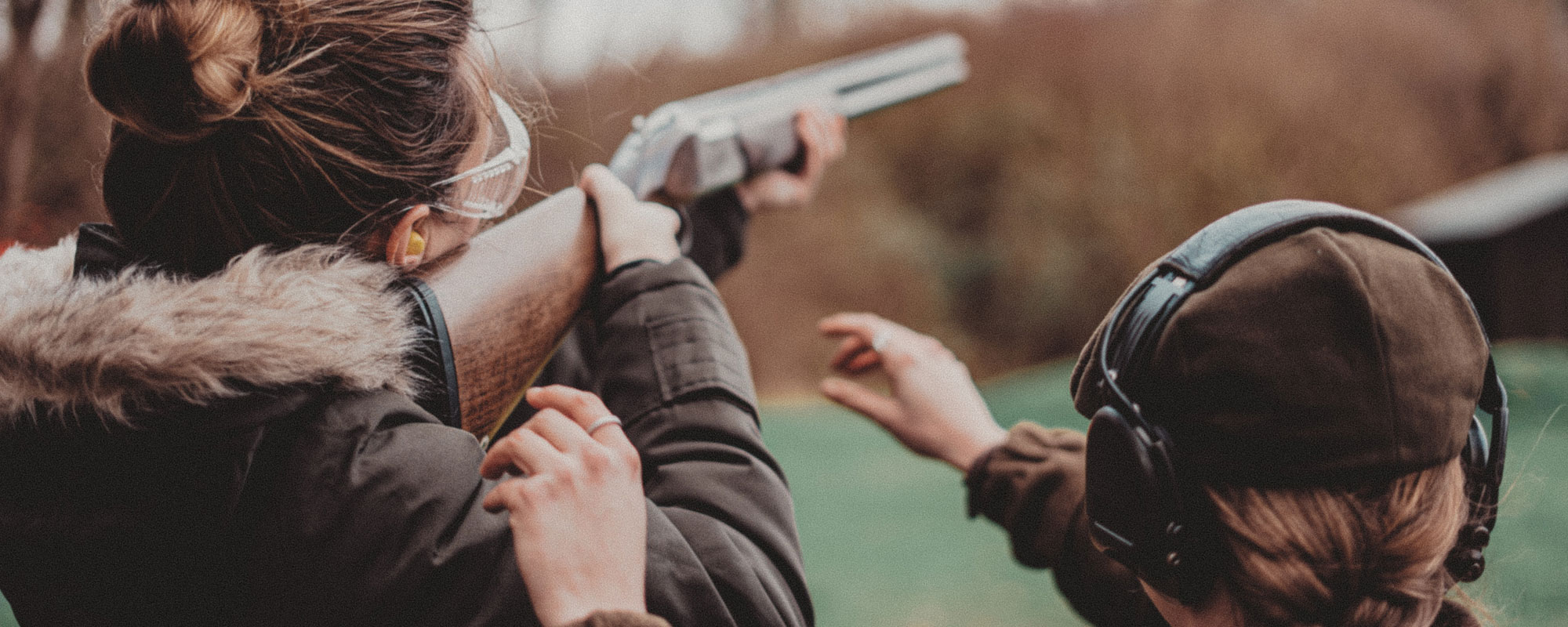 Supervised shotgun shooting practice in a field on a cold day