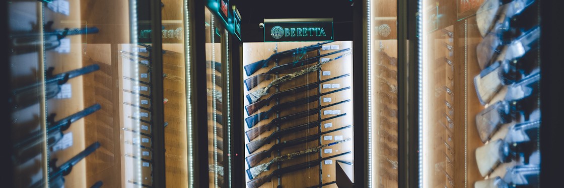 A room of display cabinates with gun in